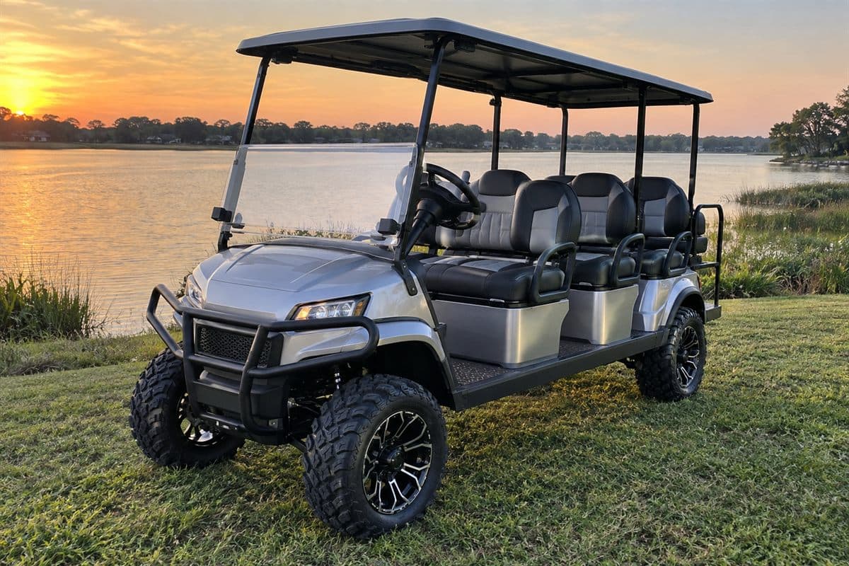 A silver six-seat lifted cart beside a lake at sunset. Watermark: Coming soon